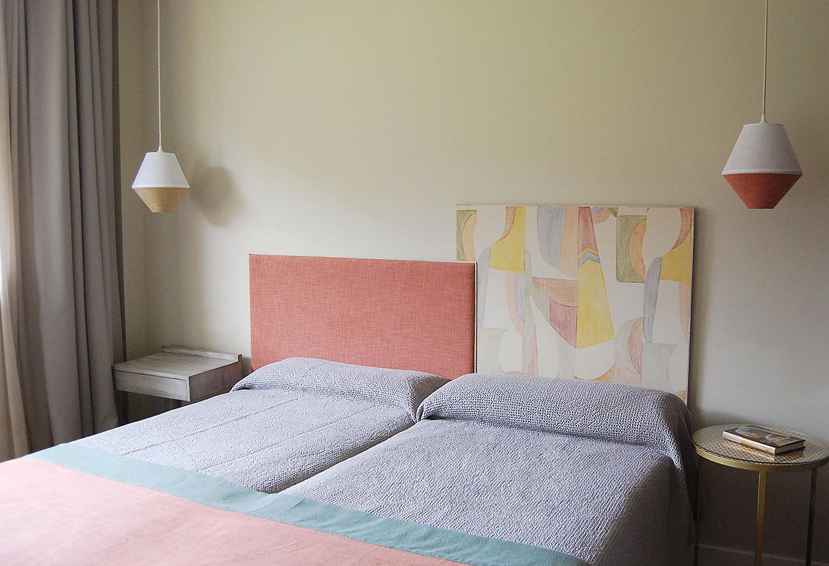 cama en habitación de hotel con mesillas y lamparas_detalle de cabecero de cama_ interiorismo para hoteles