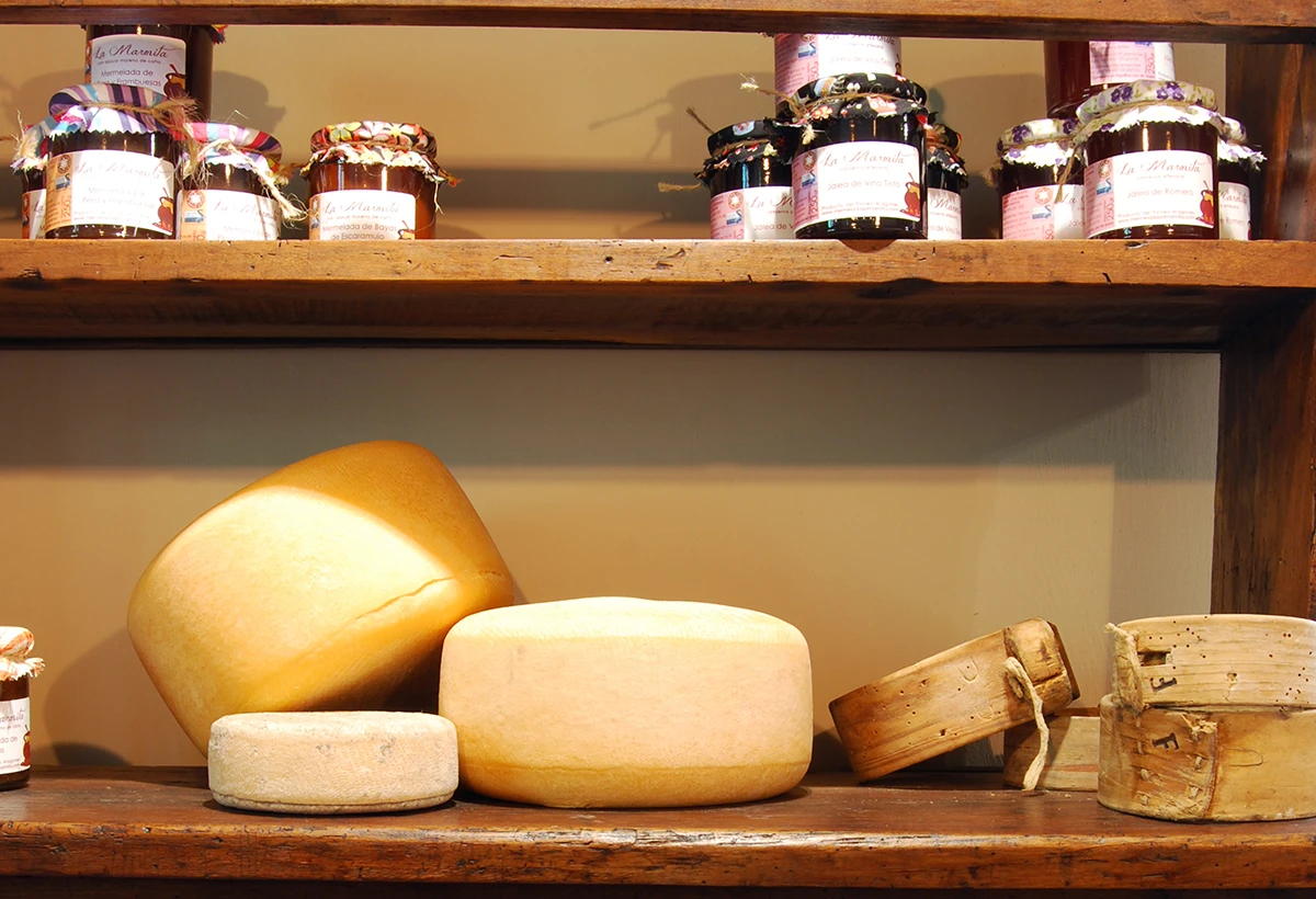 quesos y mermeladas en estantería de madera